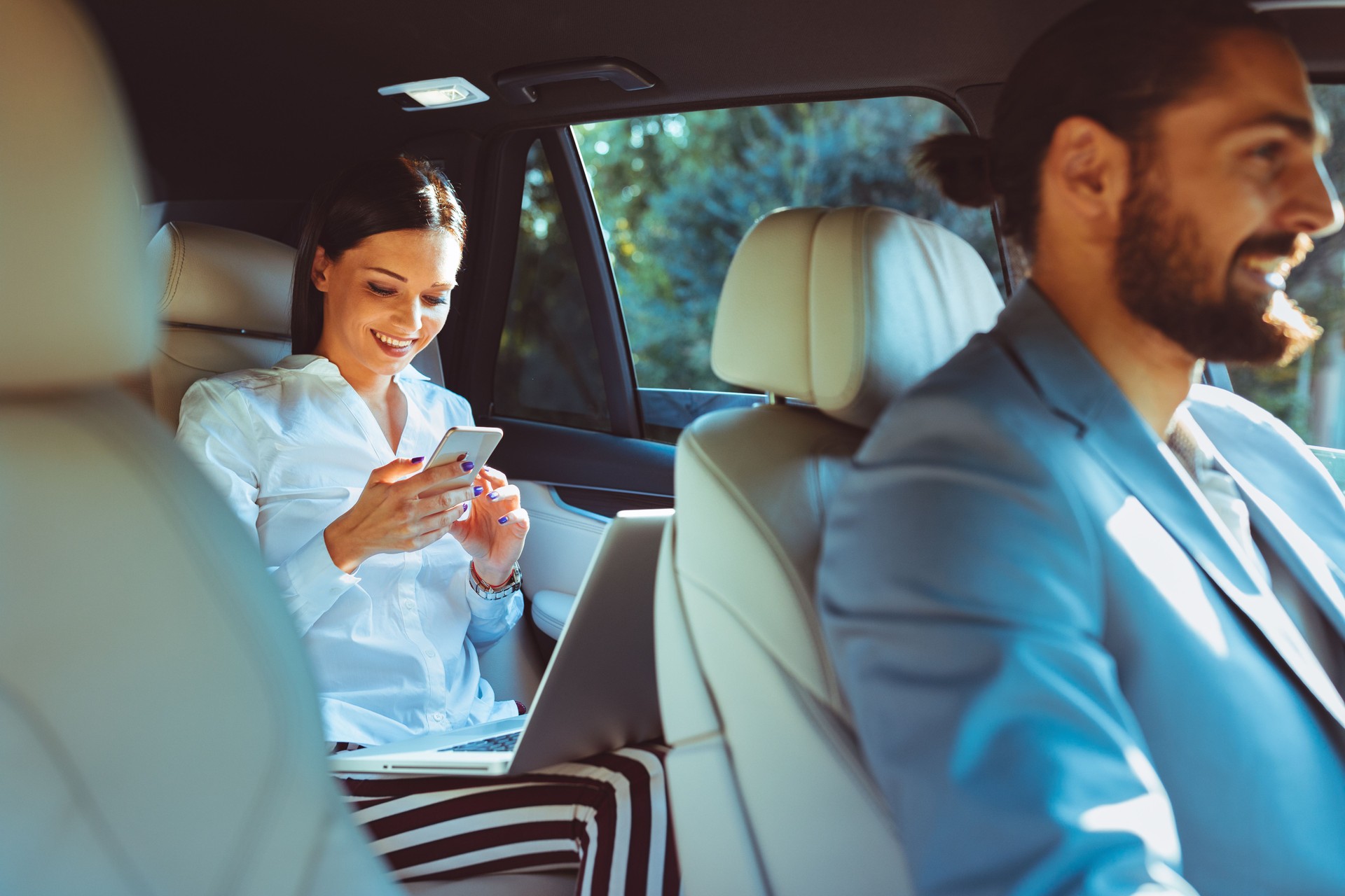 Chauffeur driven limousine with the business woman in the back seat